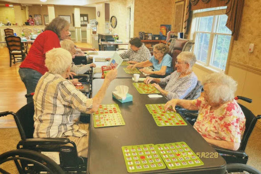 Members playing bingo with residents at an elder care facility